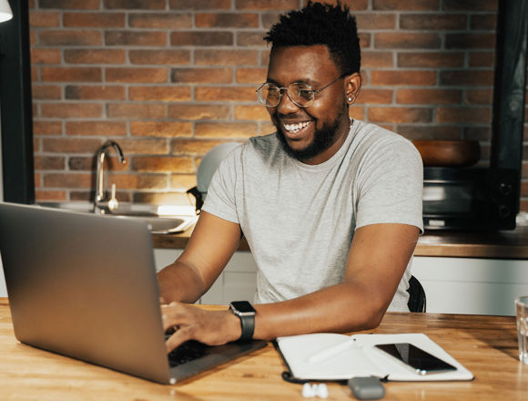 Student working on a laptop at their kitchen table.