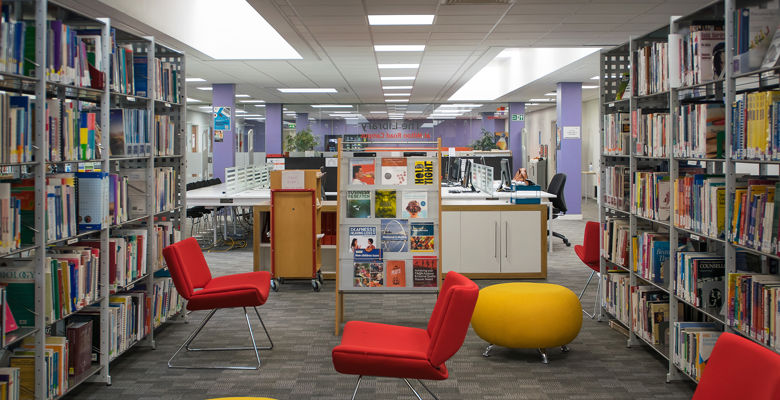 Red and yellow seats spread across the floor with bookshelves on either side.