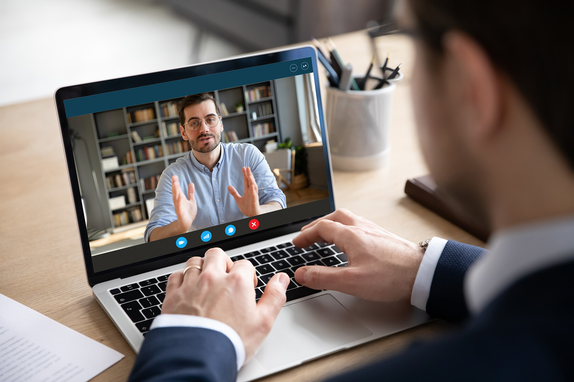 Business man wearing a suit is on a conference call on their laptop.