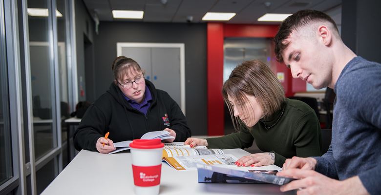 Three students looking through the college prospectus, and planning their career options.