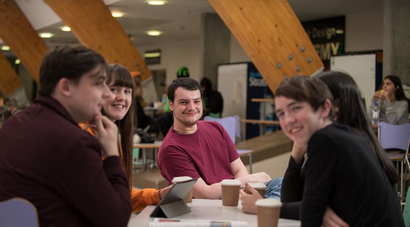 Group of students working together at a table on campus. 