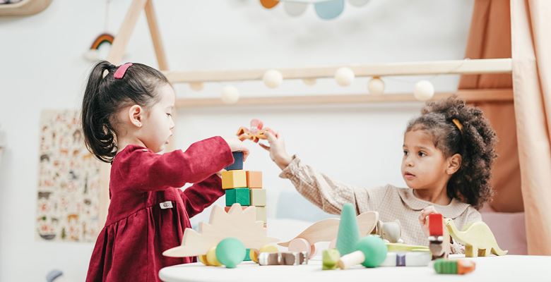 Two young children playing with blocks in a nursery.