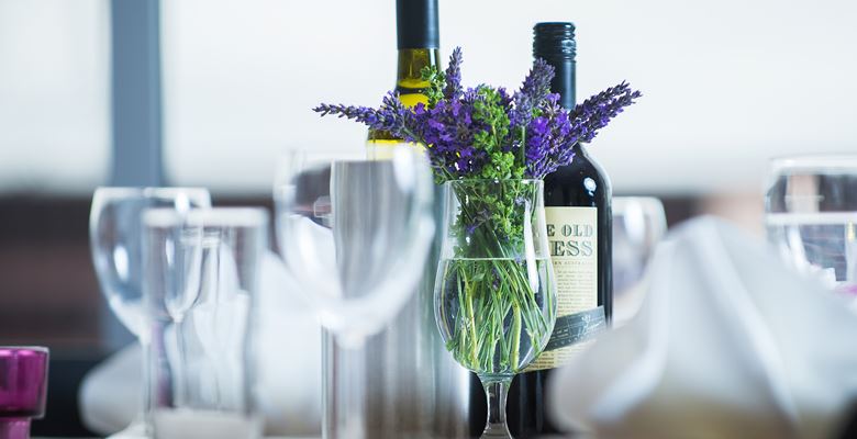 Table setting at EH15 restaurant, with flowers, wine glasses and a bottle of wine.