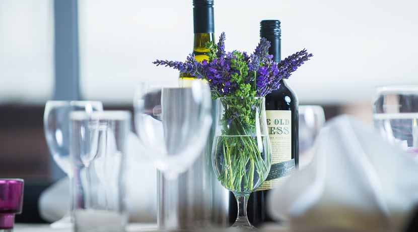 Table setting at EH15 restaurant, with flowers, wine glasses and a bottle of wine.