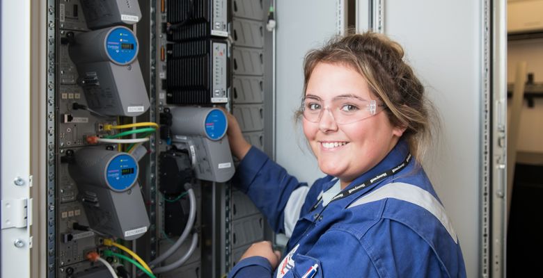 Engineering student wearing safety goggles while working with cables.