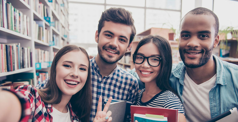 Selfie of students smiling in the library.
