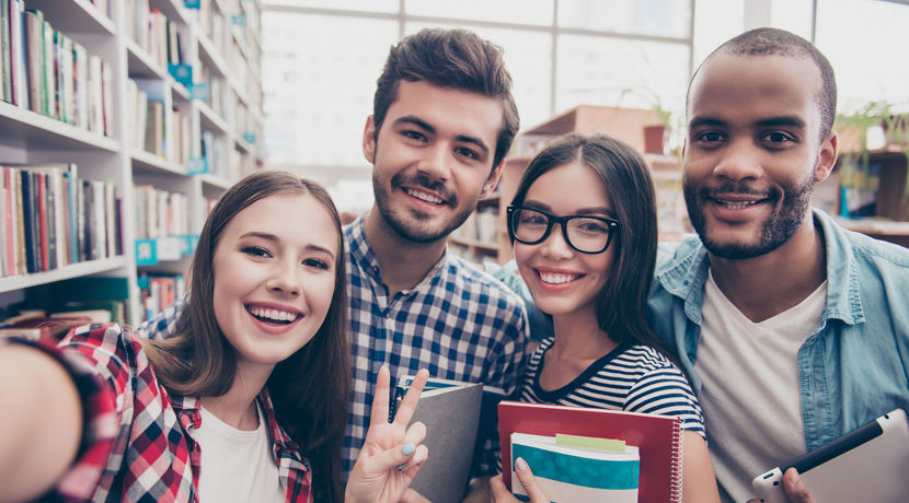 Selfie of students smiling in the library.