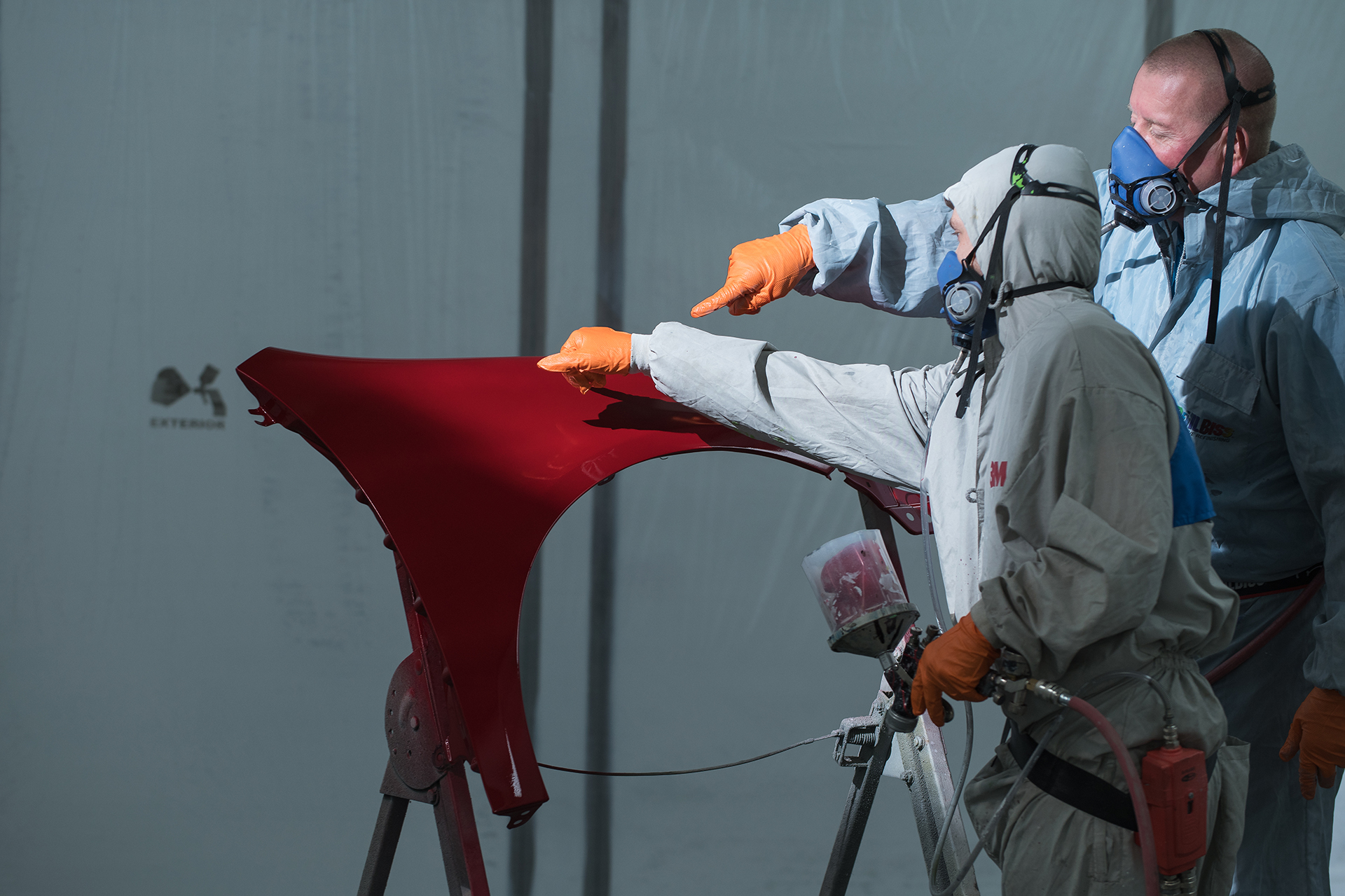 Two people wearing protective suits, masks and goggles.