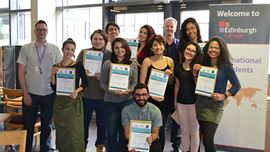 Group of international students from Brazil holding up certificates and smiling at camera. 