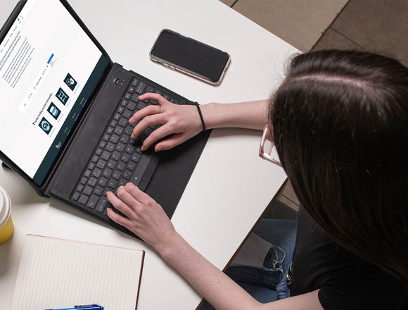 Student from above looking at the funding tool page on their laptop.
