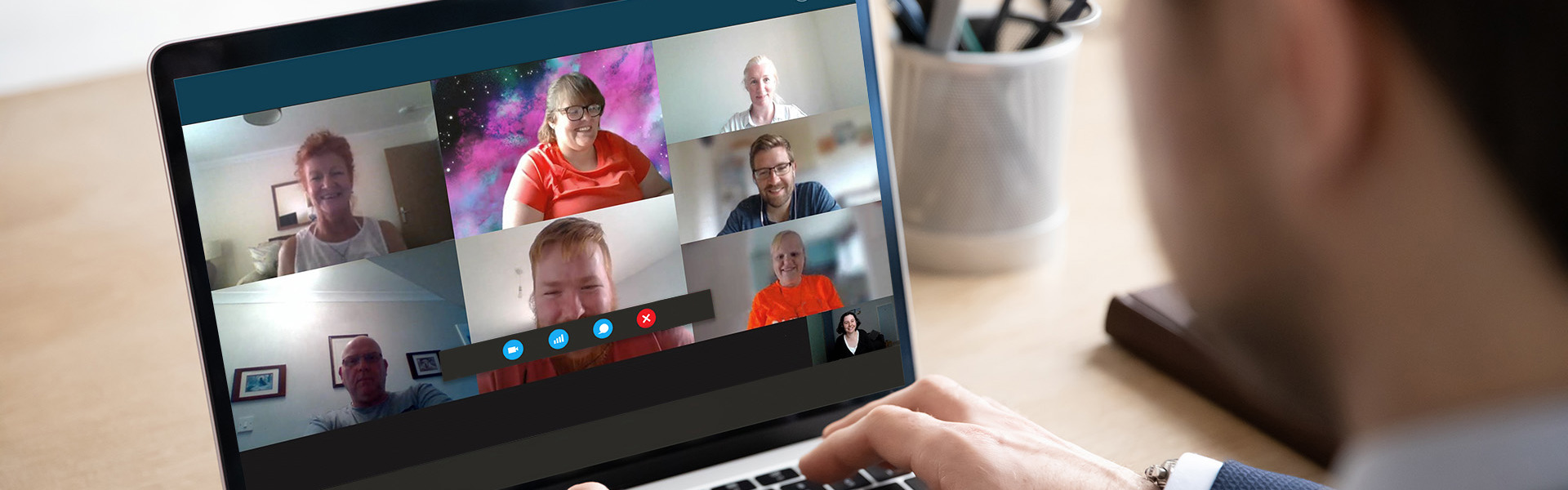 Business man wearing a suit is on a conference call on their laptop.