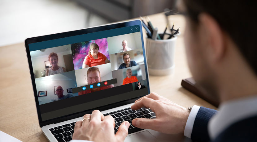 Business man wearing a suit is on a conference call on their laptop.