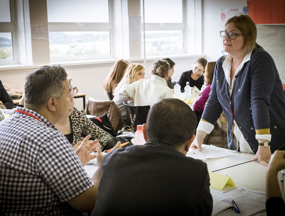 Lecturer helping a group of students studying together.