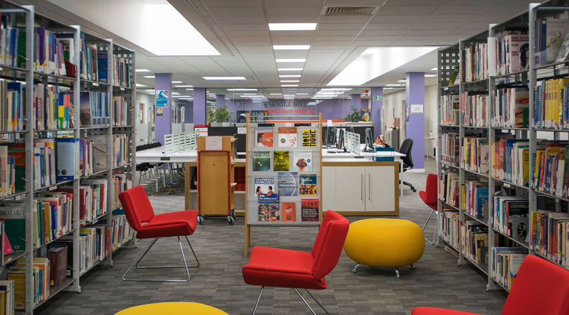 Red and yellow seats spread across the floor with bookshelves on either side.