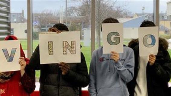 Students holding up letters that spell out Moving On