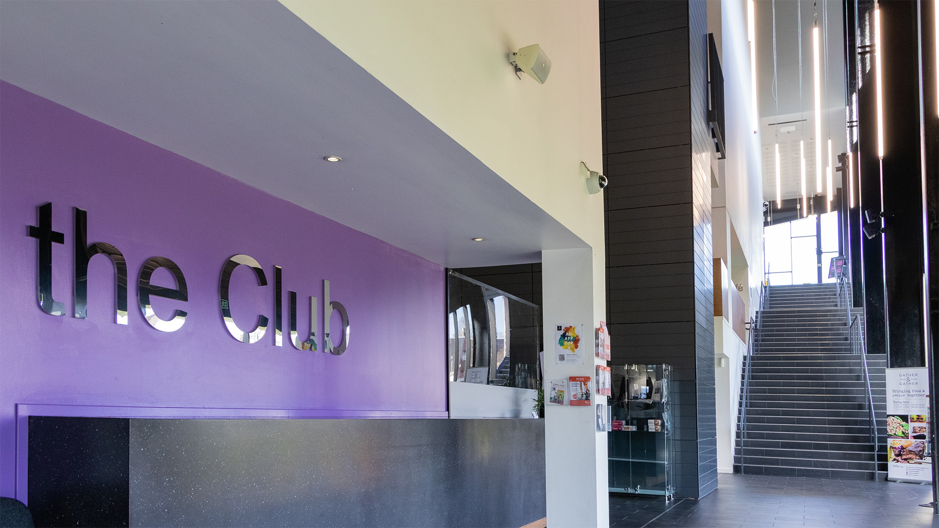 Entrance of the Club gym with a sign on the purple wall that reads 'The Club'