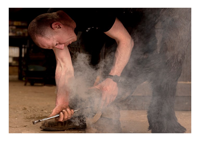 Farrier working on a horse's shoe by Lorna Fleming, submitted as part of the exhibition.