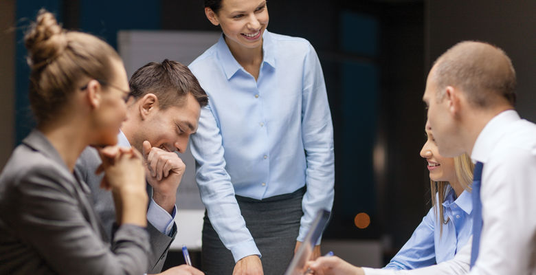 Group of employees wearing suits having a discussion at a meeting.