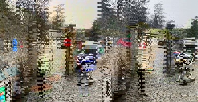 Student volunteer carrying two large white boxes, to be donated to local causes.