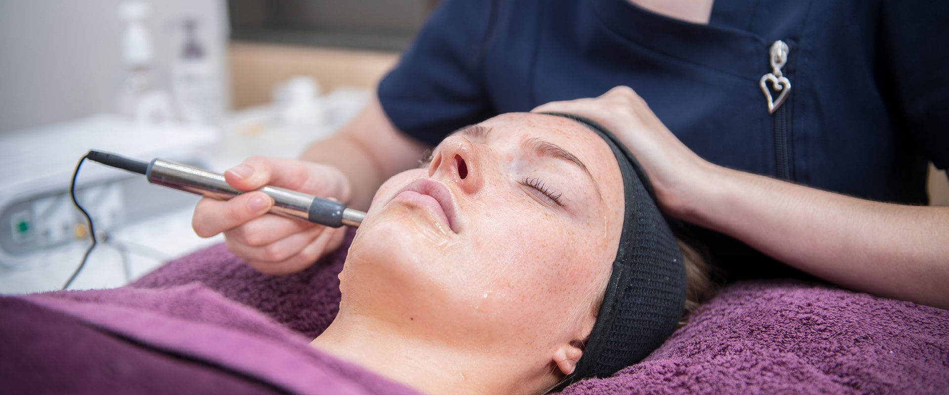 Close up of a beauty student preforming a procedure on a client's face. 