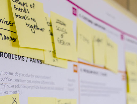Post-it notes mapped out on a larger piece of paper to make a plan.